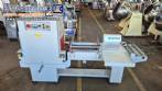 L-shaped packaging sealer with semi-automatic shrink tunnel.