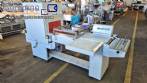 L-shaped packaging sealer with semi-automatic shrink tunnel.