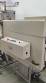 Label applicator machine with steam-operated shrink tunnel for sleeves.